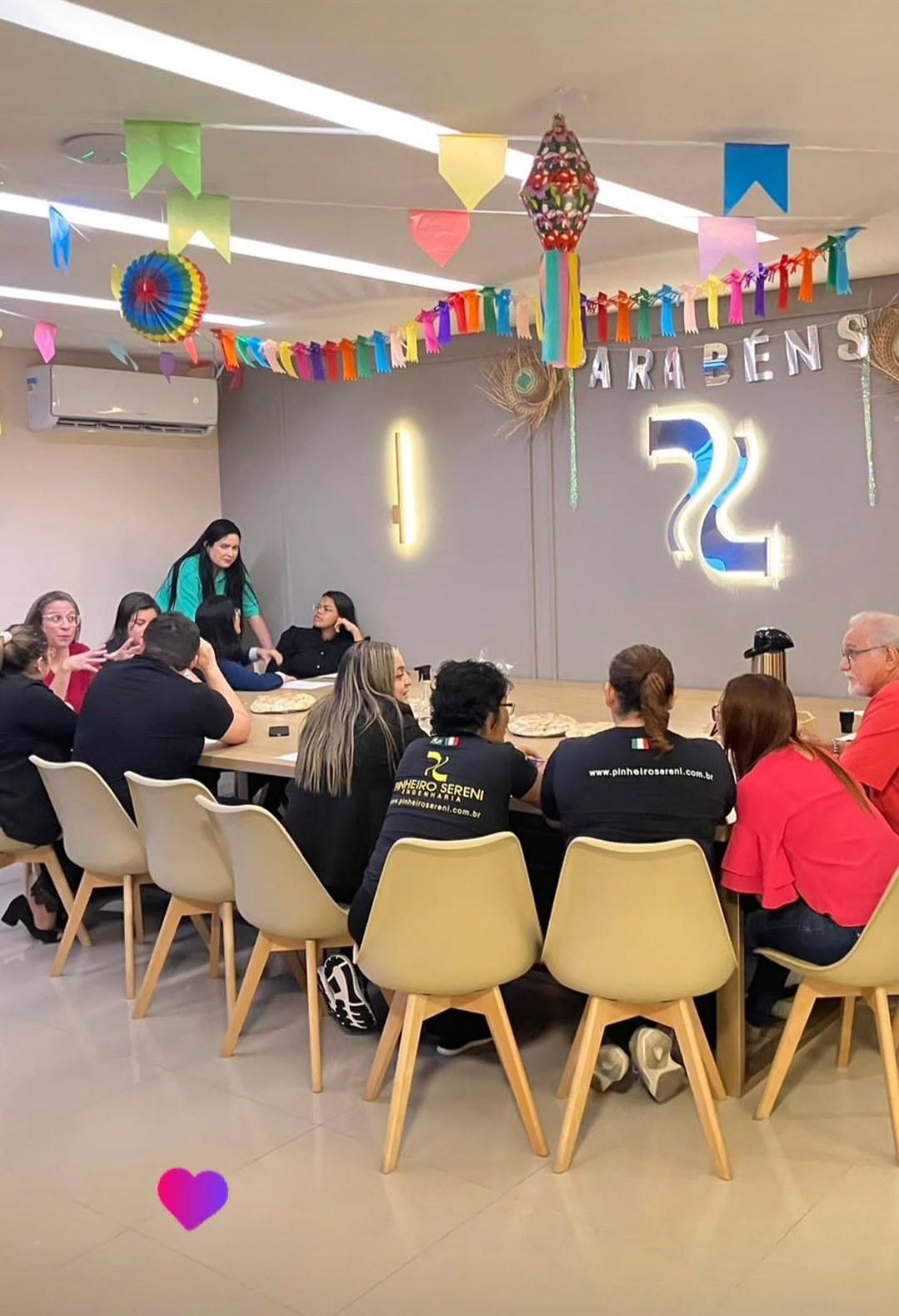 Equipe reunida em encontro temático junino em sala de convivência